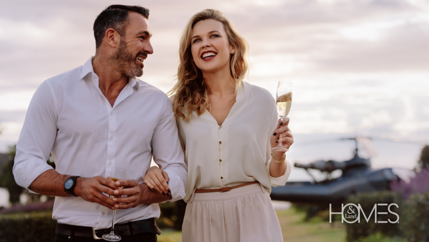 An elegant couple steps off a private helicopter, each holding a glass of champagne, ready to explore their luxurious new property. This striking image captures the sophistication and exclusivity of high-end real estate, symbolizing the successful results of a strategic marketing approach tailored to affluent clients.